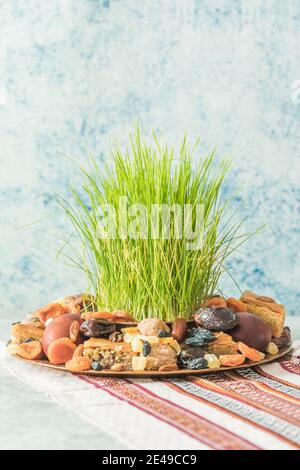 Vassoio tradizionale Novruz con semeni o sabzi di erba di grano verde, dolci e pakhlava di frutta secca su sfondo bianco. Equinox primaverile, copia dell'Azerbaigian sp Foto Stock