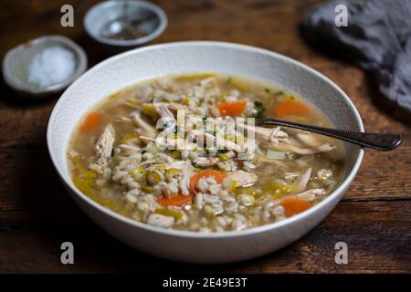 Zuppa invernale confortevole con pollo, orzo perlato e verdure Foto Stock