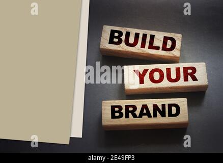 Costruisci parole di marca su blocchi di legno su sfondo nero. Concetto di business di branding marketing Foto Stock