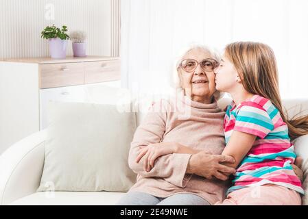 Nipote bella baciare e abbracciare nonna Foto Stock