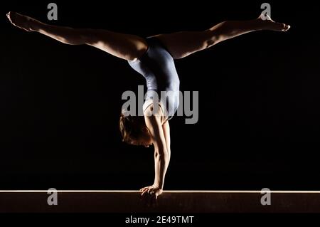 Facendo ginnasta Split Handstand sul fascio di equilibrio Foto Stock