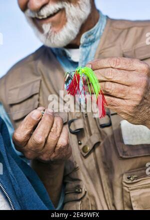 Primo piano del pescatore di mezza età con Spin Bait Foto Stock