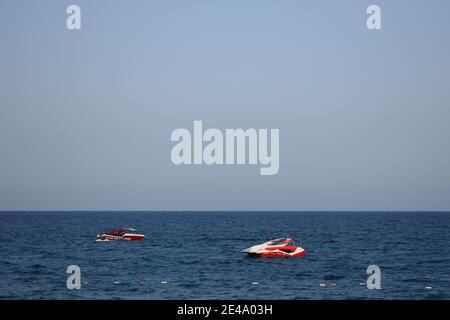 Vista sul mare dalla bellissima spiaggia con due barche a motore sulle onde del mare. Orizzonte Blu e mare Foto Stock