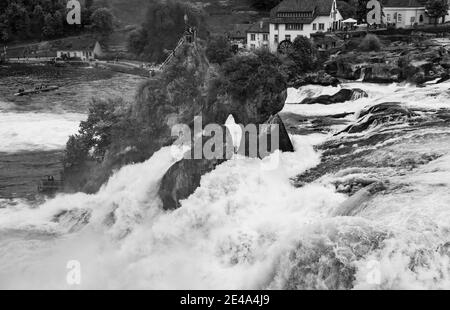 Cascate del Reno, Svizzera - 6 maggio 2017: Le cascate del Reno in bianco e nero foto paesaggio, i turisti sono sulla roccia Foto Stock