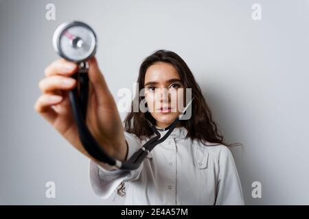 Donna smiley medico chirurgo con stetoscopio su sfondo bianco. Medecine professionale. Advert per clinica medica Foto Stock