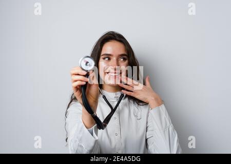 Donna smiley medico chirurgo con stetoscopio su sfondo bianco. Medecine professionale. Advert per clinica medica Foto Stock