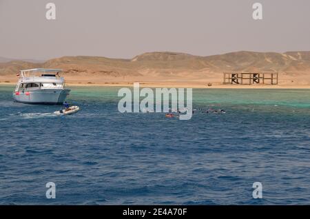 barca e molti snorkeling con barriera corallina in mare Foto Stock