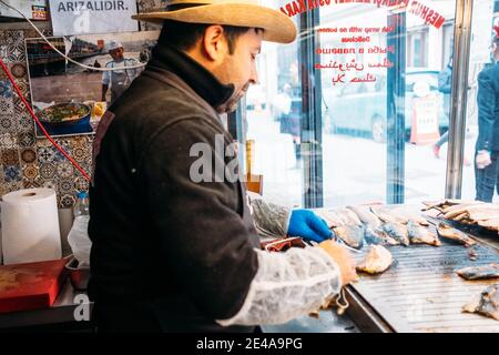 TURCHIA, ISTANBUL, 14 DICEMBRE 2018: Lo chef prepara il pesce in pita pane, Balik Durum. Foto Stock