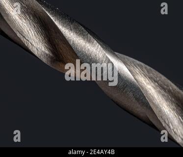 Tagli affilati delle filettature su un trapano per metallo, vista macro. Struttura della punta di ferro, primo piano. Foto Stock