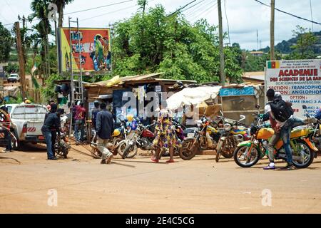 Donna in un vestito colorato che passa accanto alla fila di moto parcheggiate Foto Stock