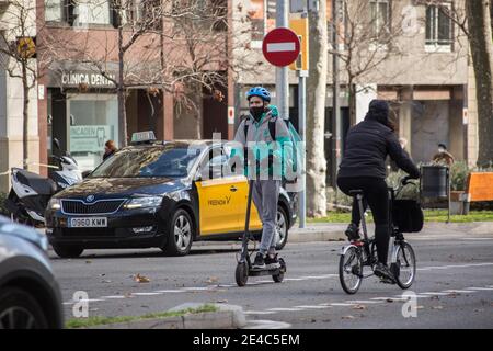 Barcellona, Catalogna, Spagna. 22 gennaio 2021. Il delivery man dell'app deliveroo è visto su uno scooter elettrico.il Ministero del lavoro spagnolo sta sviluppando un quadro legislativo che comprende l'attività di persone che effettuano consegne a domicilio, conosciute come piloti, che operano per piattaforme digitali come Glovo, Deliveroo, Just Eat o Uber Eat. La nuova legge sui Rider obbligherebbe le aziende ad assumere i loro lavoratori e quindi a porre fine alla cifra dei falsi lavoratori autonomi. Credit: Thiago Prudencio/DAX/ZUMA Wire/Alamy Live News Foto Stock