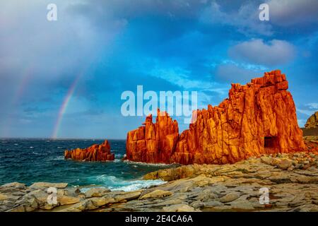 Italia, Sardegna, rocce rosse von Arbatax è un gruppo roccioso di cime di porfido rosso sangue, le cosiddette rocce rosse, che sporgono dal mare. Queste rocce, prese durante una tempesta, sono tra le attrazioni dell'isola. Foto Stock