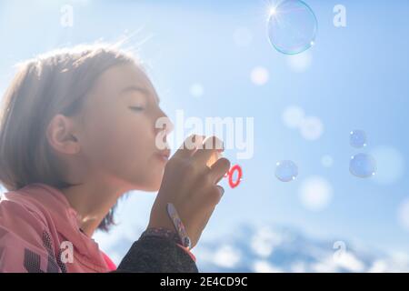 la ragazza di 10 anni gioca con bolle di sapone Foto Stock