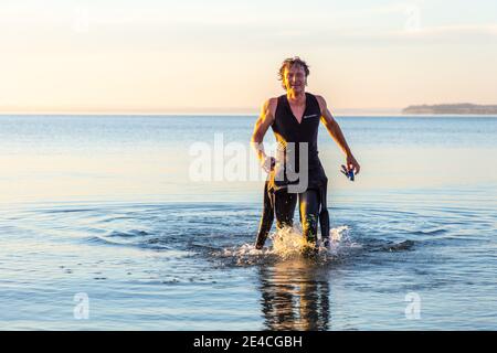 Man 50 Plus FIT, con una muta in mare. Dopo la formazione triathlon domani nel Mar Baltico Foto Stock