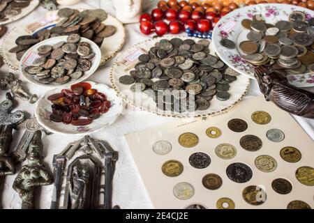 Monete, medaglie, badge e semi a tavola. Il testo nel poster significa "Banca del Libano" Foto Stock