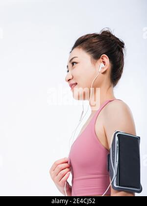 Le giovani donne in giubbotti sportivi si rilassano ascoltando musica Foto Stock