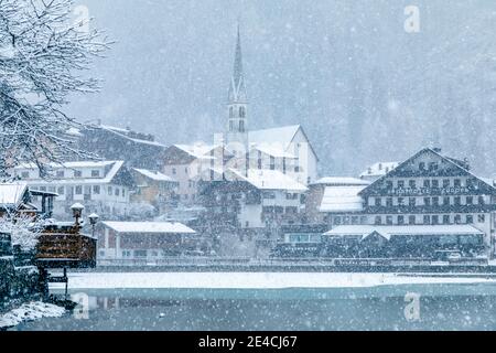 Italia, Veneto, provincia di Belluno, Agordino, Dolomiti, il villaggio di Alleghe sul lago sotto una nevicata Foto Stock