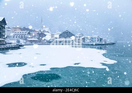 Italia, Veneto, provincia di Belluno, Agordino, Dolomiti, il villaggio di Alleghe sul lago sotto una nevicata Foto Stock