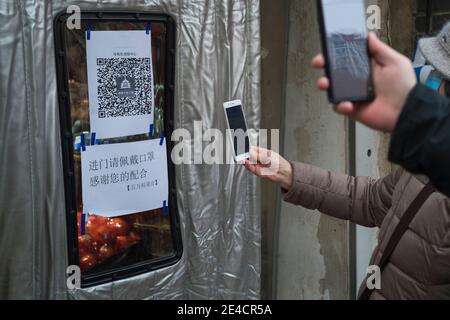 I residenti scansionano un codice QR per monitorare il proprio stato di salute prima di entrare in un supermercato a Pechino, Cina 23 gennaio 2021. Foto Stock