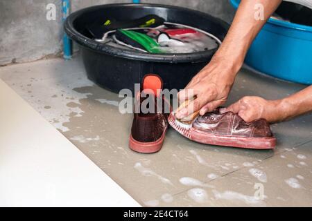 Lavando le sneakers con una spazzola di lavaggio e una polvere di lavaggio. Foto Stock