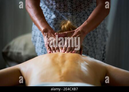 Una signora che riceve un massaggio completo dell'olio del corpo da un massaggiatrice professionale Foto Stock