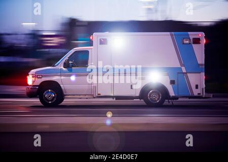 Un'ambulanza corre per rispondere alla scena di un'emergenza. Foto Stock