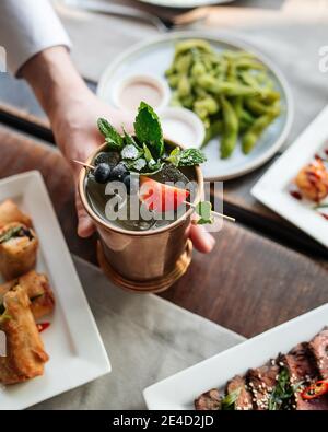 Rinfrescante cocktail di champagne in una tazza di rame Foto Stock