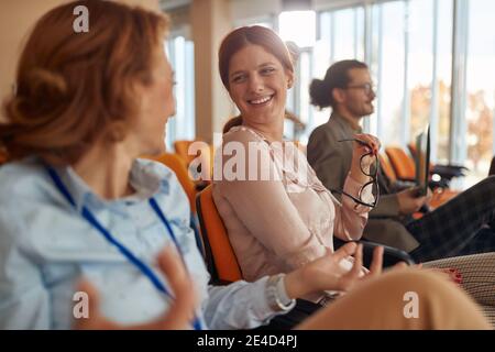 persone in sala conferenze al seminario d'affari, due donne caucasiche che parlano Foto Stock