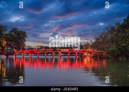 Hanoi Red Bridge di notte. Il ponte in legno dipinto di rosso sul lago Hoan Kiem collega la riva e l'isola di Jade su cui il tempio di Ngoc Son Foto Stock