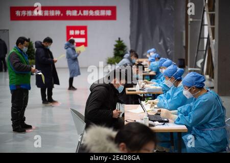 (210123) -- PECHINO, 23 gennaio 2021 (Xinhua) -- i lavoratori medici aiutano i residenti a compilare lettere di consenso informato sulla ricezione di shot di vaccino COVID-19 in un sito di inoculazione nel distretto di Chaoyang, Pechino, capitale della Cina, 2 gennaio 2021. Alla fine del 2019, il nuovo coronavirus emerse e si diffuse rapidamente in tutto il mondo. Decine di milioni di persone sono state infettate. Gli scienziati hanno isolato il virus dai pazienti e hanno chiamato il virus COVID-19. Mentre il coronavirus rovina il mondo, il vaccino è diventato una speranza per l'umanità di vincere la pandemia. Gli scienziati hanno coltivato il virus a cellule vero Foto Stock