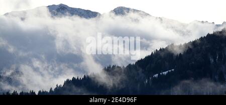 Garmisch Partenkirchen, Germania. 23 gennaio 2021. Le nuvole attraversano il Wettersteinwand nei monti Wetterstein. Credit: Angelika Warmuth/dpa/Alamy Live News Foto Stock