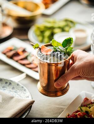 Rinfrescante cocktail di champagne in una tazza di rame Foto Stock