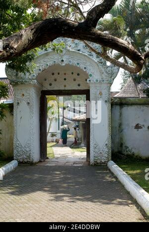 Una delle porte del palazzo di Kasepuhan Cirebon con uno stile architettonico europeo intagliato. All'interno c'erano due venditori di cibo tradizionali Foto Stock