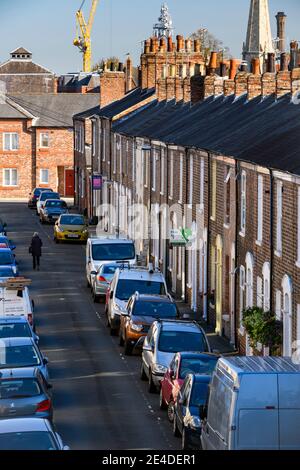 Fila di pittoresche case a schiera in mattoni rossi vittoriani (cottage) e molte auto parcheggiate su strada (problema di parcheggio) - Bishophill, York, Inghilterra, Regno Unito. Foto Stock