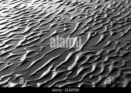 Una vista ravvicinata delle strutture di sabbia a bassa marea su una spiaggia Foto Stock