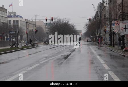 Berlino, Germania. 23 gennaio 2021. I passanti attraversano la strada Unter den Linden, quasi priva di veicoli, sotto la pioggia battente. Credit: Paul Zinken/dpa/Alamy Live News Foto Stock