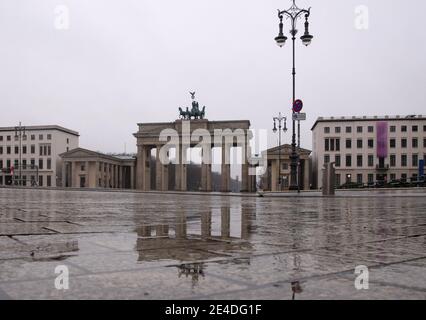 Berlino, Germania. 23 gennaio 2021. La porta di Brandeburgo si riflette nell'acqua piovana di Pariser Platz. Credit: Paul Zinken/dpa/Alamy Live News Foto Stock