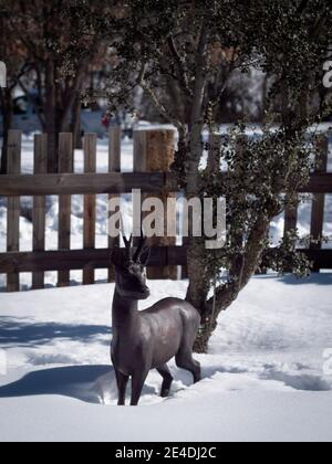 Scultura orizzontale di capriolo di bronzo da una quercia nella neve. Foto Stock