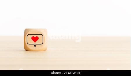Icona cuore social media su blocco di legno. Spazio di copia. Sfondo bianco Foto Stock