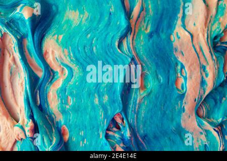 Texture volumetrica astratta in fluide artistica di colore blu e tonalità arancio. Tratti di vernice ruvidi. Spesso strato pesante di schiuma acrilica colorata scorrevole Foto Stock