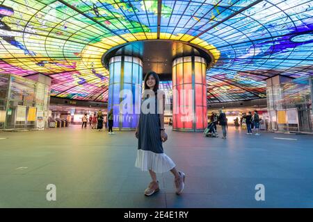 Bella posa turistica di fronte a Formosa Boulevard, una delle più belle stazioni della metropolitana del mondo, Kaohsiung, Taiwan Foto Stock