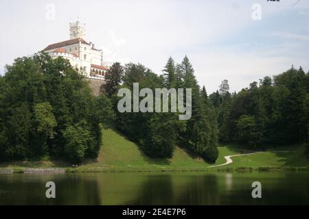 Un castello medievale in cima alla collina, sul lago, circondato da una fitta foresta Foto Stock