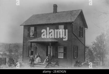 Archivio americano ritratto monocromatico di due coppie seduti su un portico casa. Preso nel tardo 19 ° secolo a Port Byron, New York, Stati Uniti Foto Stock