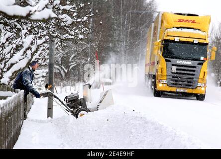 VADSTENA, SVEZIA - 6 DICEMBRE 2012: Qualcuno che rimuove la neve con il suo lancianeve. Un camion che passa su una strada invernale. Foto Gippe Gustafsson Foto Stock