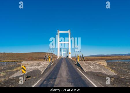 Anello lastricato che attraversa il Golden Gate Bridge delle Highlands nel deserto vulcanico dell'Islanda, paesaggio vulcanico del campo di lava, in estate e blu Foto Stock