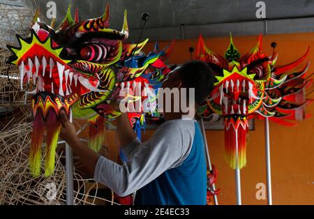 Bogor, Indonesia. 23 gennaio 2021. Un artigiano creatore di leoni (Barongsai) e drago (Liong) costumi da ballo, ispeziona le sue creazioni all'interno della sua casa prima delle celebrazioni lunari di Capodanno, a Bogor, Indonesia il 23 gennaio 2021. Milioni di cinesi in tutto il mondo celebreranno il nuovo anno lunare, il 2021 è l'anno dell'Ox, che cade il 12 febbraio in mezzo alla pandemia globale del coronavirus COVID-19. (Foto di Adrian/INA Photo Agency/Sipa USA) Credit: Sipa USA/Alamy Live News Foto Stock