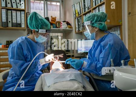 Gerusalemme, Israele - 17 gennaio 2021: Un dentista e il suo assistente, completamente protetti contro la contaminazione da virus corona, durante un trattamento dentale. Foto Stock