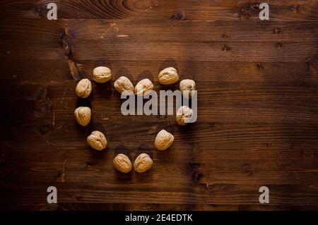 composizioni di noci sagomate su sfondo di legno per una sensazione naturale Foto Stock