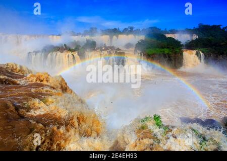 Rainbow in the spray sopra le iconiche Cascate di Iguazu al confine tra Brasile e Argentina, vista al mattino dal lato brasiliano Foto Stock