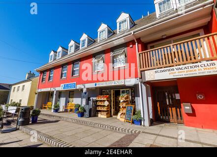 Street scene: Una piccola sfilata tipica di negozi locali nella strada principale di St Davids, una piccola città cattedrale in Pembrokeshire, Galles sud-occidentale Foto Stock